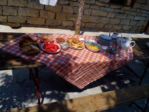 a picnic table with plates of food on a blanket at Camp Panorama in Guča