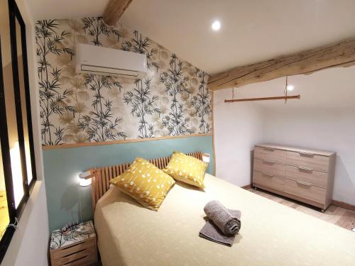 1 dormitorio con 1 cama con almohadas amarillas en Maisonnette en Luberon, en Cadenet