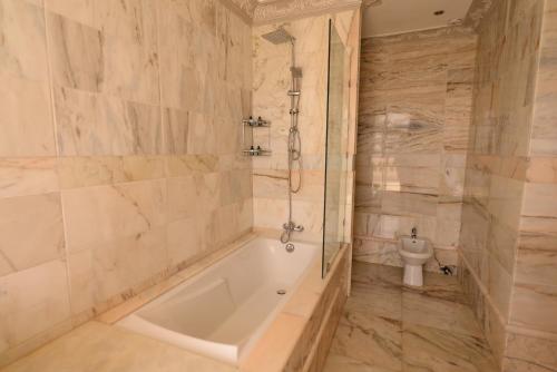a bathroom with a tub and a toilet at THE WHITE PALACE Rabat in Rabat