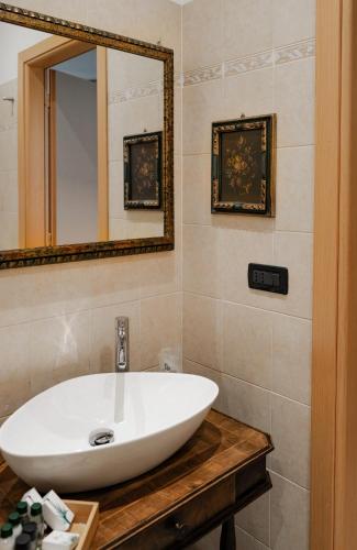 a bathroom with a white sink and a mirror at Convento Boutique Hotel in Susa