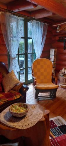 Prigorka, a fairytale house في Jasenak: غرفة معيشة مع أريكة وكراسي وطاولة