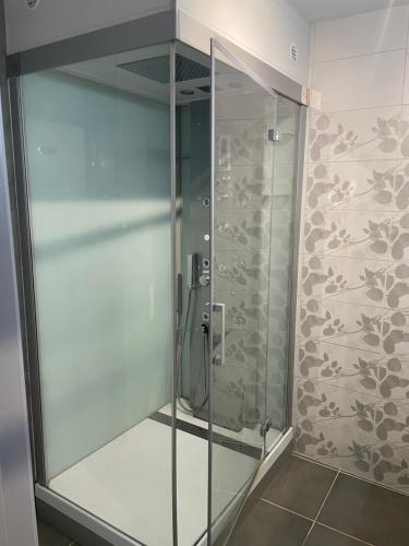 um chuveiro com uma porta de vidro na casa de banho em T3 refait à neuf em Fleurance