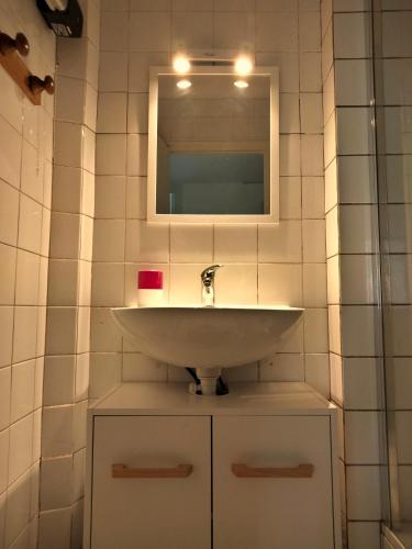 une salle de bain avec un lavabo et un miroir dans l'établissement Appart coeur de village - proche des criques, à Port-Vendres