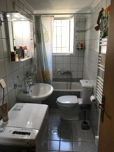a bathroom with a sink and a toilet and a tub at Cozy Apartment Near City Center in Preveza