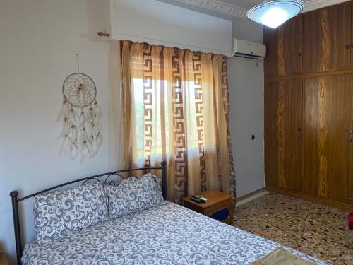 a bedroom with a bed and a window with curtains at Anita's hosting in Kalamata