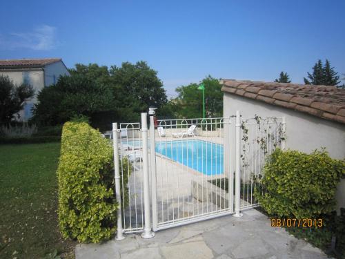 un portail blanc avec une piscine derrière dans l'établissement La Frandomière, à Saint-Martin-de-Londres