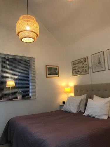 a bedroom with a bed and a chandelier at Tobisborg 1 Simrishamn in Simrishamn