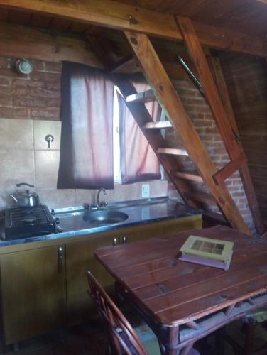 cocina con mesa de madera y fregadero en Paraje del Molino Casa Alpina, en San José