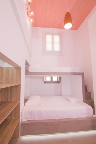 a small bedroom with a bed in a loft at Ialemos Group in Symi