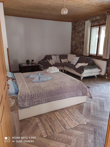 1 dormitorio con 1 cama grande y 1 sofá en Bujtina Vila Dodo, en Leskovik