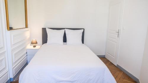um quarto com uma cama com lençóis brancos e uma janela em Les Matelots Rouen Centre by MyFrenchPAT em Rouen