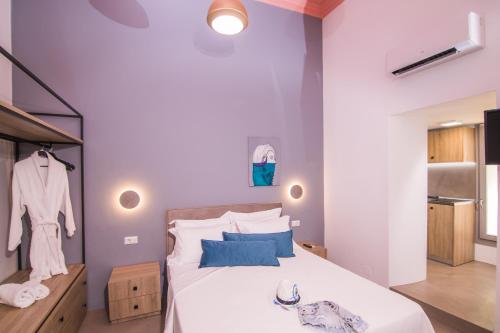 a bedroom with a bed with white sheets and blue pillows at Ialemos Group in Symi