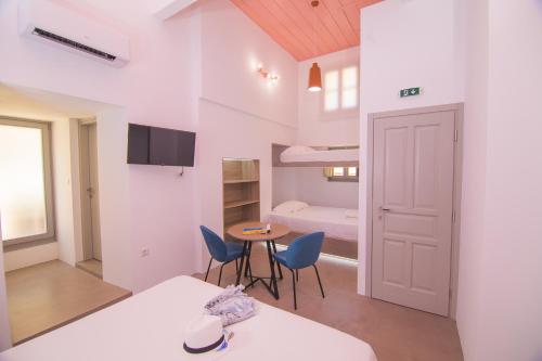 a small room with a bed and a table and chairs at Ialemos Group in Symi