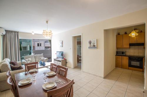 - une salle à manger et un salon avec une table et des chaises dans l'établissement Merab Holidays Apartment Castalia 62, à Ayia Napa