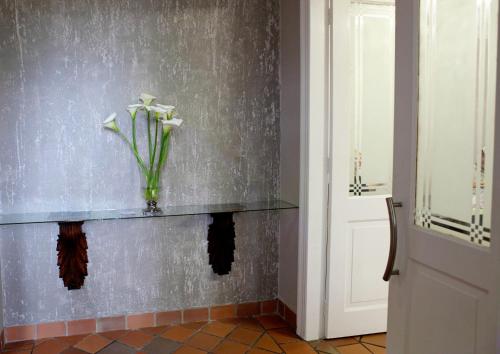 a vase with white flowers on a shelf in a room at Elegant Lodge & Conference Center in Pongola