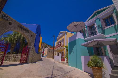 a street with colorful buildings and an umbrella at Ialemos Group in Symi