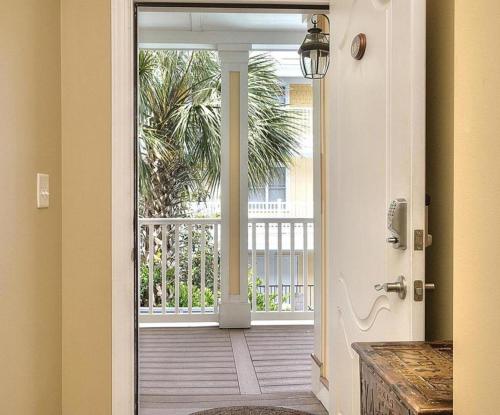eine offene Tür zu einem Balkon mit einer Palme in der Unterkunft Rock N Reel in Oak Island