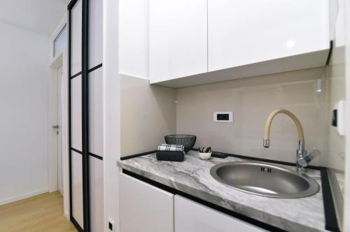 Studio Apartman Dream في رييكا: حمام مع حوض ودواليب بيضاء