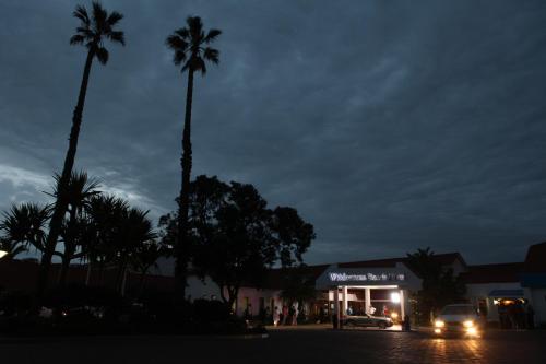 a night view of a shopping center with palm trees at Wilderness Beach Hotel in Wilderness