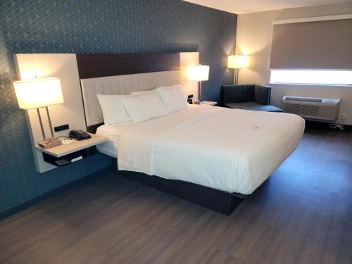 a hotel room with a bed and a night stand at La Quinta by Wyndham Santa Rosa in Santa Rosa