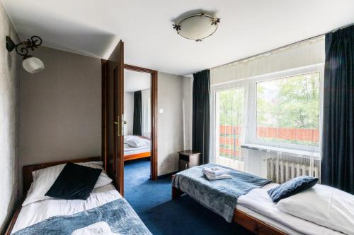 una camera d'albergo con due letti e una finestra di Willa Biały Domek - 600m Krupówki a Zakopane