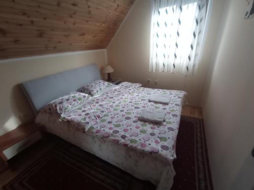 a small bedroom with a bed in a room with a window at Holiday Home Usovic in Žabljak