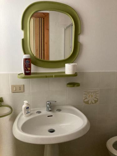 y baño con lavabo y espejo verde. en All’Ulivo saraceno, en Trabia