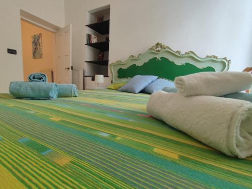a large bed with a green headboard and pillows on it at La Casetta del Bianconiglio con Garage in Genoa
