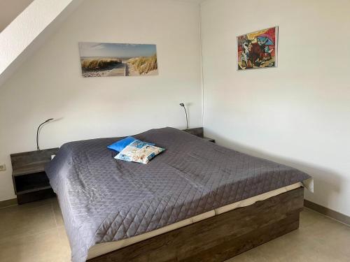 - un lit dans une chambre avec 2 photos sur le mur dans l'établissement Ferienwohnung Lieblingsplatz-Greetsiel, à Greetsiel