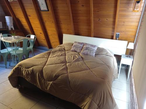 a bed in a room with a wooden wall at Quedate Apart Hotel in Correa