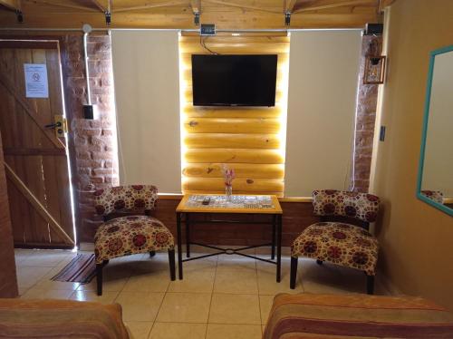 a room with a table and two chairs and a tv at Quedate Apart Hotel in Correa