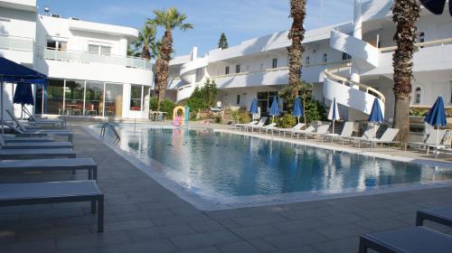 
a swimming pool with a pool table and chairs at Paleos Hotel Apartments in Ialyssos
