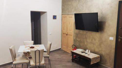 sala de estar con mesa y TV en la pared en Affitto turistico - La Terrazzina, en Monterotondo