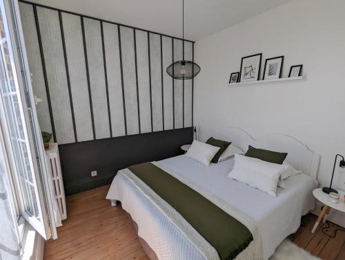 - une chambre dotée d'un grand lit avec des oreillers blancs et verts dans l'établissement Le Bois, à Honfleur