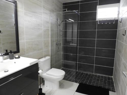a bathroom with a toilet and a sink and a shower at Ti Kaz À Patou, au coeur de l'île. in Baie-Mahault