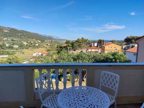 a table and chairs on a balcony with a view at Apartments Velinka in Rab