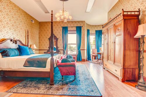 a bedroom with a canopy bed and a red chair at The Bressmer in Springfield