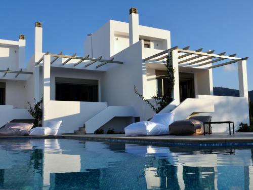 a villa with a swimming pool in front of a house at Manna Gea in Vonitsa