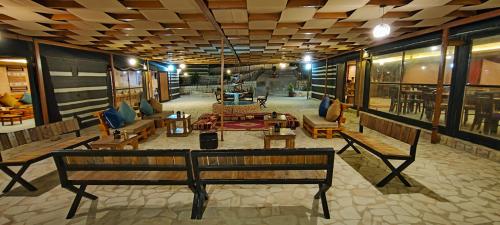 a lobby with benches and tables in a building at Petra Wassaif Camp in Wadi Musa