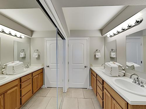 ein Badezimmer mit zwei Waschbecken und zwei Spiegeln in der Unterkunft Regency Towers 302 West in Pensacola Beach