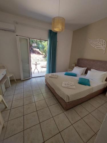 a bedroom with a bed and a sliding glass door at Maria Studios in Paleokastritsa