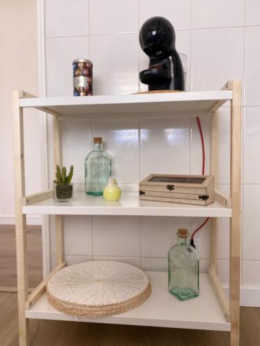 a shelf with glass bottles and a telephone at Casa Margarida in Apúlia
