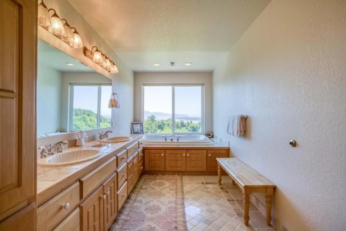a bathroom with two sinks and a tub and a window at Netarts Lookout - Meredith Lodging in Netarts