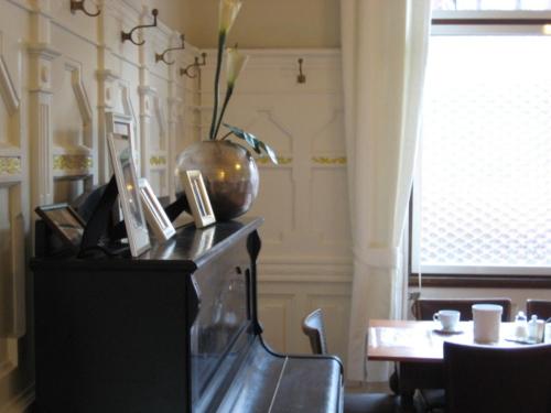 a piano in a dining room with a table and a tableablish at Hotel Markgräfler Hof in Karlsruhe