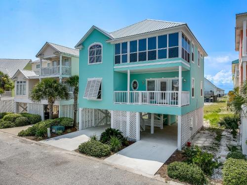 a blue house with a balcony on a street at ABearadise in Gulf Shores