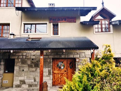 un edificio con una puerta de madera y un cartel en él en Periko´s Youth Hostel en San Carlos de Bariloche