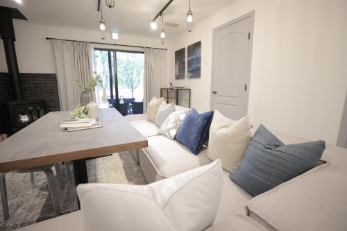 a living room with a white couch and blue pillows at SAUNA FOREST CABIN 軽井沢 御代田 A棟 zen-asobi in Oiwake