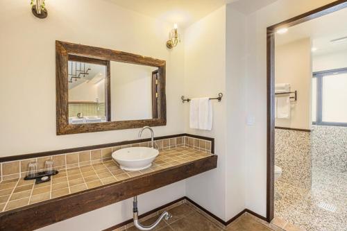 a bathroom with a sink and a mirror at Olle Resort in Jeju