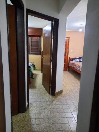 a hallway with a door open to a bedroom with a bed at Apart Centro- VICTORIA555 in Libertador General San Martín