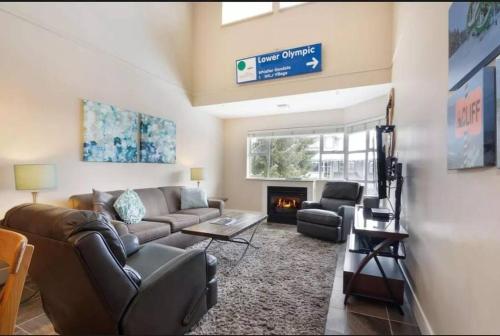 a living room with a couch and a fireplace at Ski-in Ski-out at upper village next to Fairmount Hotel In Whistler in Whistler